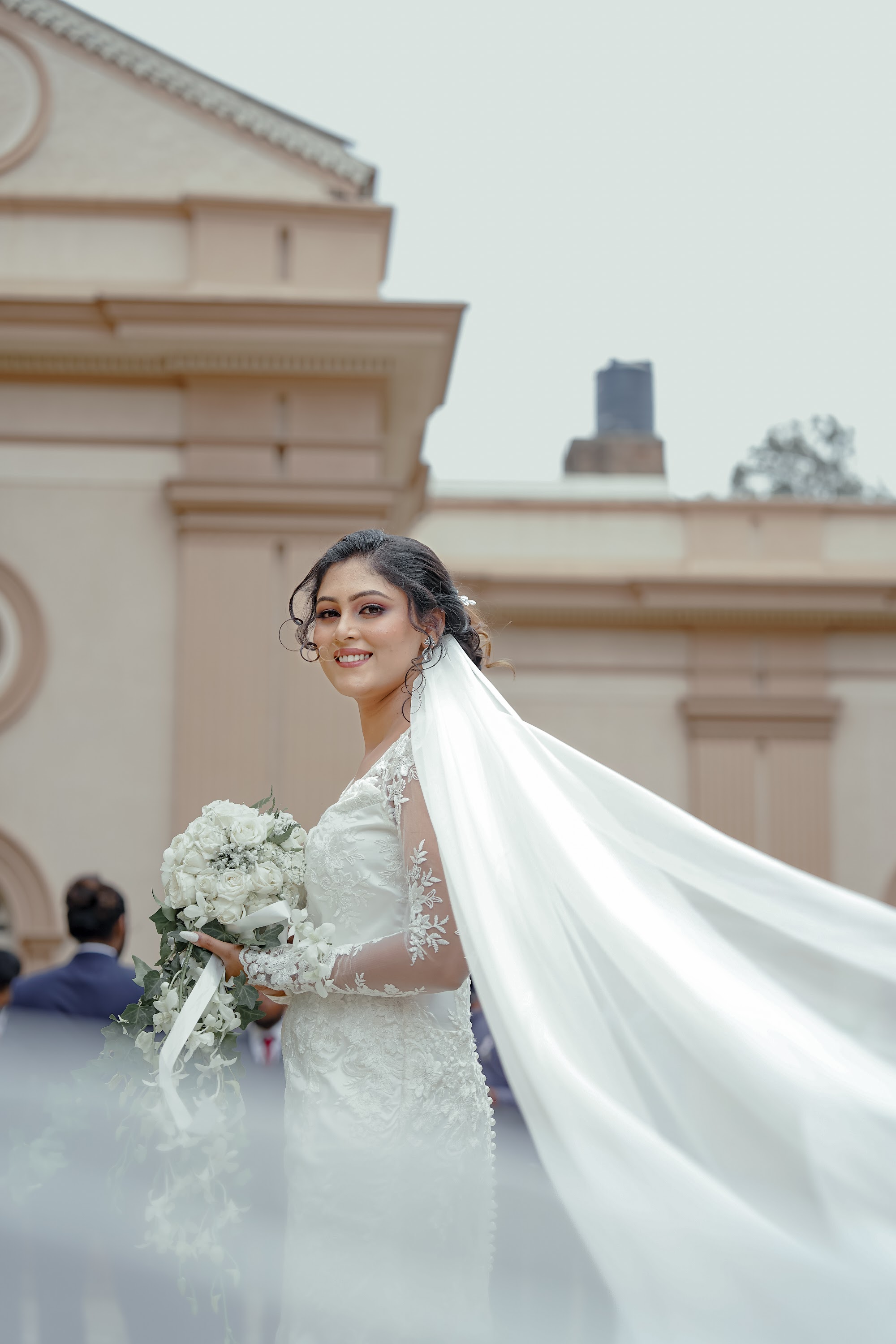 Bride under her veil with bouquet